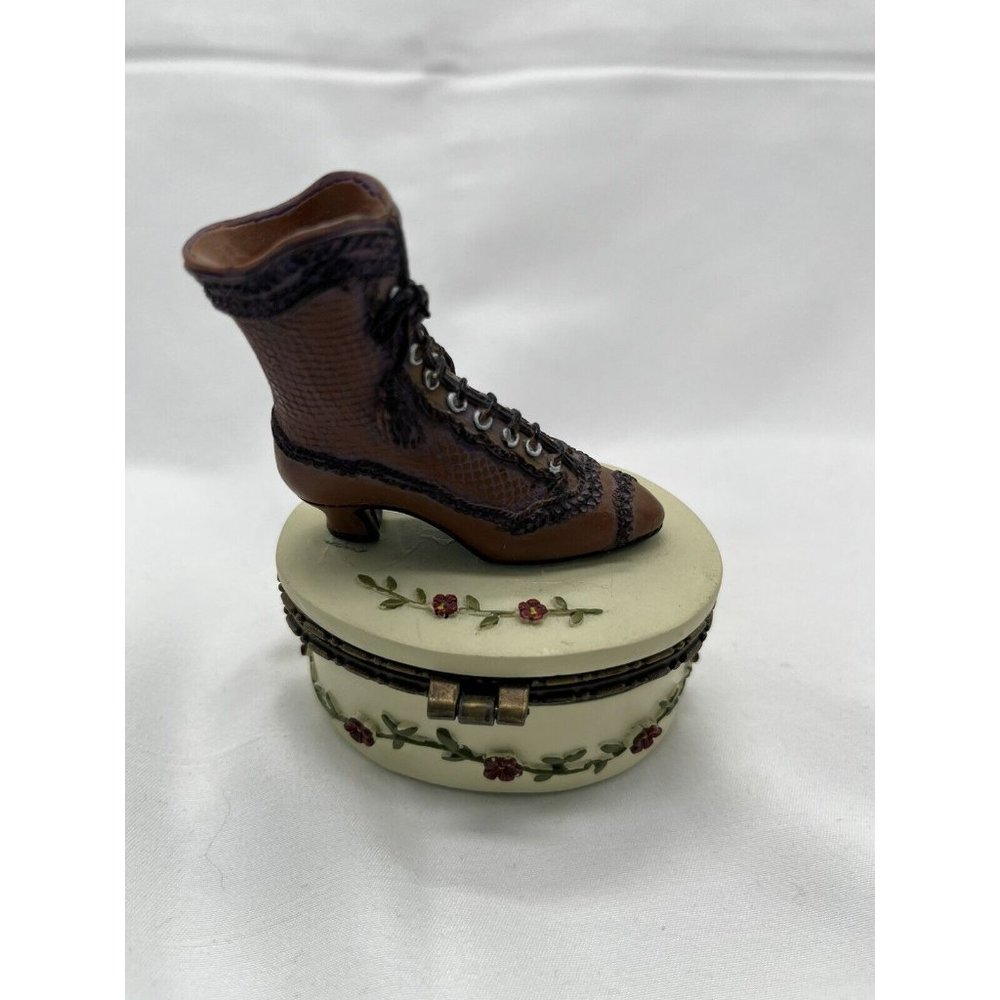 victorian shoe trinket on top of white box with red roses on vine